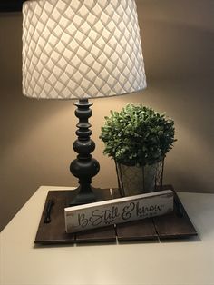 a lamp that is sitting on top of a table next to a potted plant