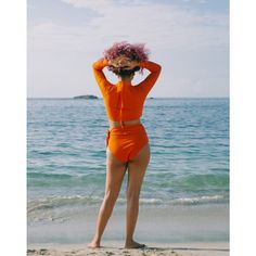 MIGA Swimwear's Cutout Long Sleeve Top in Burnt Orange is perfect for an active lifestyle. It features a flattering cutout in the chest, stylish mock-neck and a long zipper pulley for ease of use. This bikini top is made with sustainable SPF 50 fabrics that protect your skin. Fitted Solid Color Athleisure Swimwear, Stretch Solid Color Rash Guard For Beach, Fitted Rash Guard For Summer Workout, Athleisure Fitted Rash Guard For Beach, Sporty Fitted Solid Swimwear, Fitted Rash Guard For Sports, Orange Stretch Swimwear For Workout, Orange Stretch Workout Swimwear, High Stretch Swimwear For Surfing