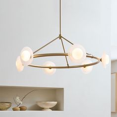 a chandelier hanging from the ceiling in a room with bowls and vases