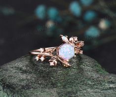 a white opal ring sitting on top of a rock