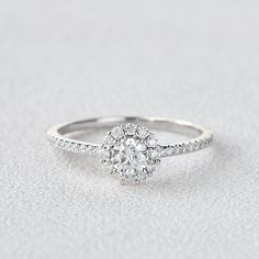 a white gold engagement ring with diamonds on the band and an oval center stone in the middle