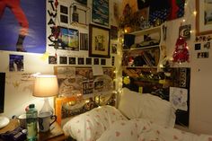 a bed room with a neatly made bed and lots of pictures on the wall above it