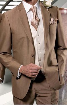 a man in a brown suit and white shirt with a rose on his lapel