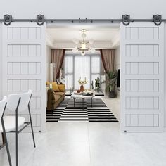 an open door leading to a living room with white walls and black and white striped rug