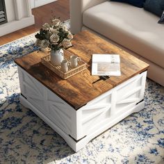 a coffee table sitting on top of a blue and white rug next to a couch