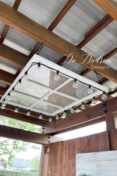 the inside of a building with lights hanging from it's ceiling and wood paneling