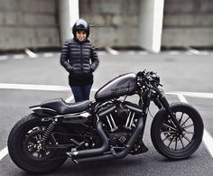 a person standing next to a black motorcycle