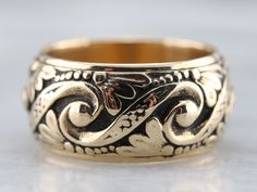 Crafted by the Art Carved company in the mid-1900s, this vintage yellow gold band features an ornate pattern of swirls, dots, and botanical motifs in a comfortable width. This will look nice all on its own, stacked with other bands or up against a vintage style engagement ring! Metal: 14K Yellow Gold Width of Band: 10.2 mm Height off Finger: 2.4 mm Ring Size: 7.50 Marks: "14K{ARTCARVED" Stamped on the inside band Luxury Artisan Carved Rings, Luxury Traditional Carved Rings, Mens Ring Antique, Posey Ring, Ornate Pattern, Botanical Motifs, Vintage Wedding Jewelry, Vintage Style Engagement Rings, Band Art