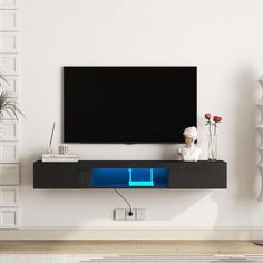 an entertainment center with a flat screen tv mounted on it's side, in front of a white wall