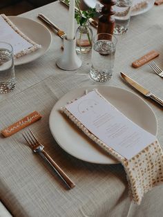 the table is set with silverware and place settings