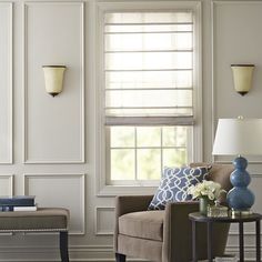 a living room with white walls and blue accents on the windowsills, two couches and a coffee table in front of them