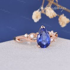 a close up of a ring with a blue stone in the middle and white diamonds around it