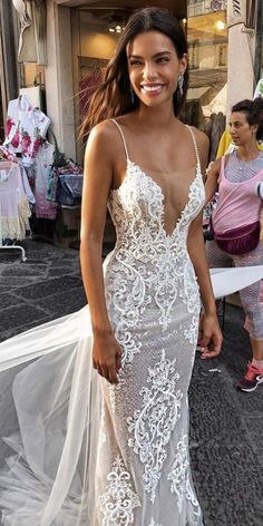 a woman in a white dress standing on the street