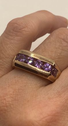 This is a vintage purple amethyst with amethyst sidestones set in golden 925 sterling We have in size 11 this can be sized to your specification, our jeweler charges $10-$20 please message us to discuss sizing your ring or engraving options. All of our jewelry is hand polished and shipped to you in a stylish gift box. We are happy to gift wrap for you. It is important to us that each customer be thrilled with their purchase. We are grateful for thousands of positive reviews. Purple Ruby Ring For Formal Occasions, Classic Purple Amethyst Ring, Formal Purple Ruby Ring, Classic Amethyst Round Band Ring, Formal Purple Amethyst Ring With Vvs Clarity, Formal Purple Ruby Ring With Center Stone, Classic Amethyst Ring Stamped 14k, Gold Amethyst Ring With Vvs Clarity, Classic Amethyst Birthstone Ring For Anniversary