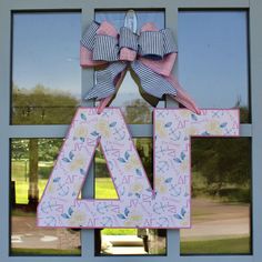 the front door is decorated with pink and blue letters, bows, and an air sign