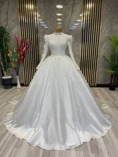 a white wedding dress on display in a room