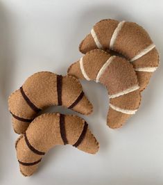 three brown croissants sitting on top of a white table next to each other