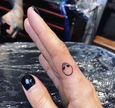 a woman's finger with a small tattoo on it, and a smiley face