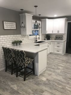 a kitchen with white cabinets and gray tile flooring