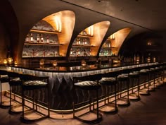 a dimly lit bar with stools in front of it