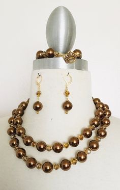 "Brown double strand necklace set crafted by adding brown faux pearl beads, light topaz rondelle facet crystal beads, and goldtone flower spacer beads together to make this set. The findings are gold metal. Necklace 17\" long Bracelet 8 1/2\" long Earrings 2 1/2\" long" Brown Pearl Necklace, Cherry Necklace, Brown Earrings, Pearl Necklace Set, Beaded Necklace Designs, Brown Necklace, Color Cafe, Rainbow Necklace, Pearl Jewelry Sets