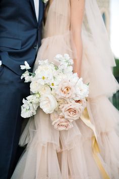 the bride and groom are wearing tuxedos with flowers on their lapel covers