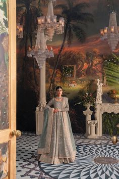 a woman standing in front of a chandelier