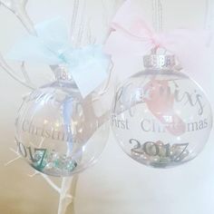 two christmas baubles with bows hanging from them