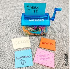 several sticky notes are placed next to a blue toy typewriter with writing on it