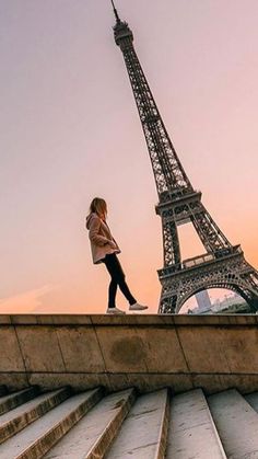 a woman walking up some steps towards the eiffel tower