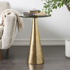 a living room with a chair, table and potted plant on the floor next to it