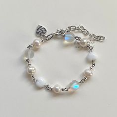 "A sweet handmade bracelet ✿ Made with freshwater pearls, glass crystal beads, metal accents, and glass beads ✿ Pearlescent white, clear with aqua hues, white, and silver ✿ The bracelet has an additional 1-1.5\" of extension chain. Some beads may be added or removed depending on the length selected" Elegant White Moonstone Beaded Bracelets, Elegant White Moonstone Crystal Bracelet, White Pearl Charm Bracelets For Jewelry Making, Silver Bracelets With Pearl Chain And Round Beads, Silver Beaded Moonstone Bracelets, White Beaded Chain Pearl Bracelet Gift, Silver Pearl Crystal Bracelet For Gift, White Pearl Chain Round Bracelets, White Moonstone Round Crystal Bracelet