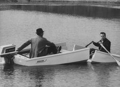 two men in a small boat on the water