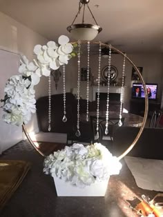 a mirror with flowers and pearls hanging from it's sides in a living room