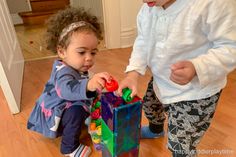 two young children playing with toys on the floor