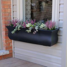 a window box filled with flowers on the side of a house