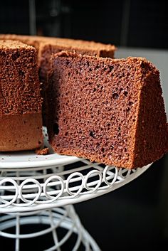 a cake sitting on top of a white plate next to a slice of chocolate cake