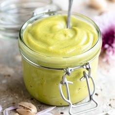 a jar filled with green liquid sitting on top of a table next to some garlic