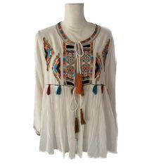 Beautifully Embroidered 40% Cotton, 60% Rayon Super Lightweight Swingy Jacket. More Like Cover For The Hot Summer Days. Relaxed Fit. Exclusive Beads Embellishments At The Front. Unlined, Tassel Detailing, Long Sleeves, Tie Closure At Front. Super Bohemian Style, Perfect For Hot Weather . Hand Wash Cold. White Color White Long Sleeve Outerwear With Tassels, Winter Long Sleeve Tops With Tassels, Cream Long Sleeve Festival Blouse, White Spring Outerwear With Tassels, Festival Long Sleeve Cream Blouse, Cream Long Sleeve Blouse For Festival, Bohemian Blouse With Multicolor Embroidery For Fall, White Tasseled Outerwear For Spring, Spring Embroidered Long Sleeve Top With Hem Detail