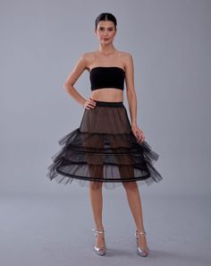 a woman is wearing a black and brown dress with sheer tulle on the bottom