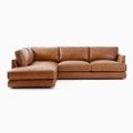 a brown leather sectional sofa sitting on top of a white floor