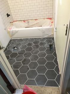 a bathroom that is being remodeled with tile on the floor and in the bathtub