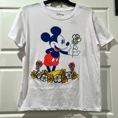 New, Never Worn Disney Tee Sporting Iconic Mickey Mouse With Flowers. He’s Holding A Daisy Embroidered Flower. Disney T-shirt For Fan Events In Spring, Spring Cotton Mickey Mouse Top, Spring Mickey Mouse Cotton Top, Spring Mickey Mouse Crew Neck T-shirt, Mickey Mouse Crew Neck T-shirt For Spring, White T-shirt For Disney Trips In Summer, Casual Mickey Mouse T-shirt For Spring, Spring Mickey Mouse Short Sleeve Top, Cute White Tops For Disney Trips