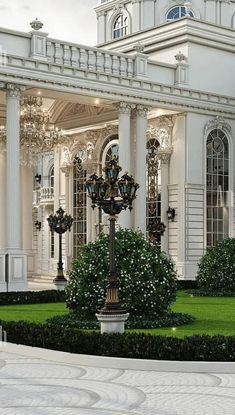 a large white building with columns and pillars in front of it, surrounded by greenery