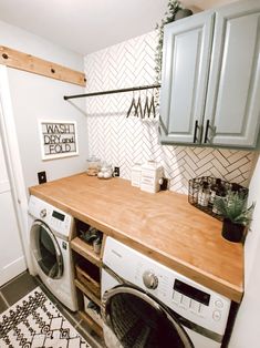 a washer and dryer in a small room with wooden counter tops on the floor