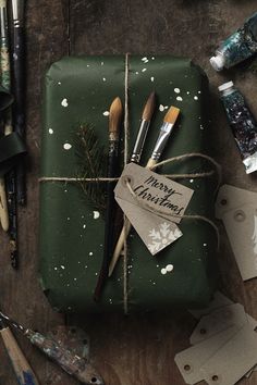 a present wrapped in green paper and tied with twine, surrounded by other crafting supplies