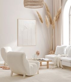 a living room with white furniture and large windows