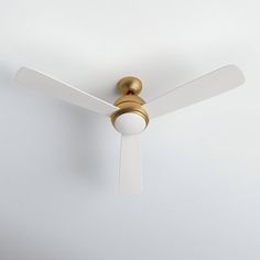 a white ceiling fan with a gold finish on the blades and a light bulb attached to it