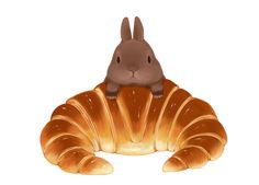 a brown bunny sitting on top of a croissant