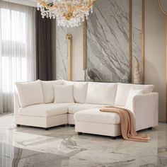 a living room with marble flooring and a white couch in front of a chandelier